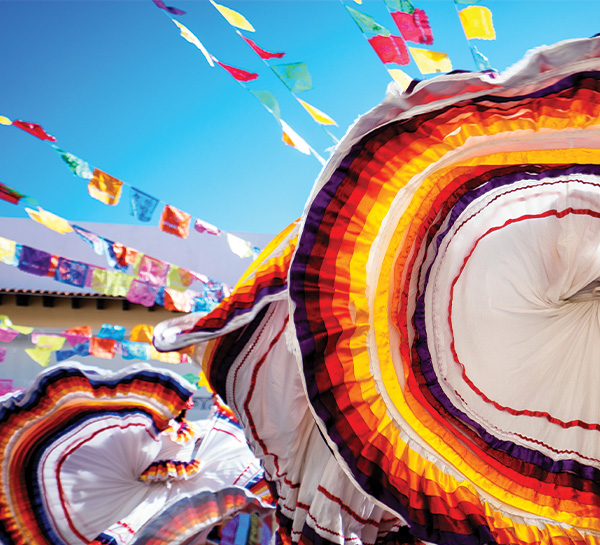 A photo of circular fabrics blowing in the wind. Featuring vibrant orange and yellow colors